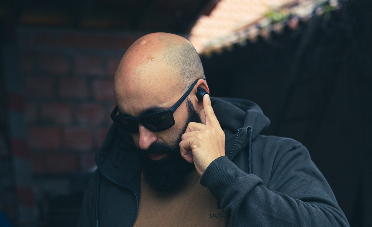 Man wearing EARMOR M20T PRO electronic earbud outdoors